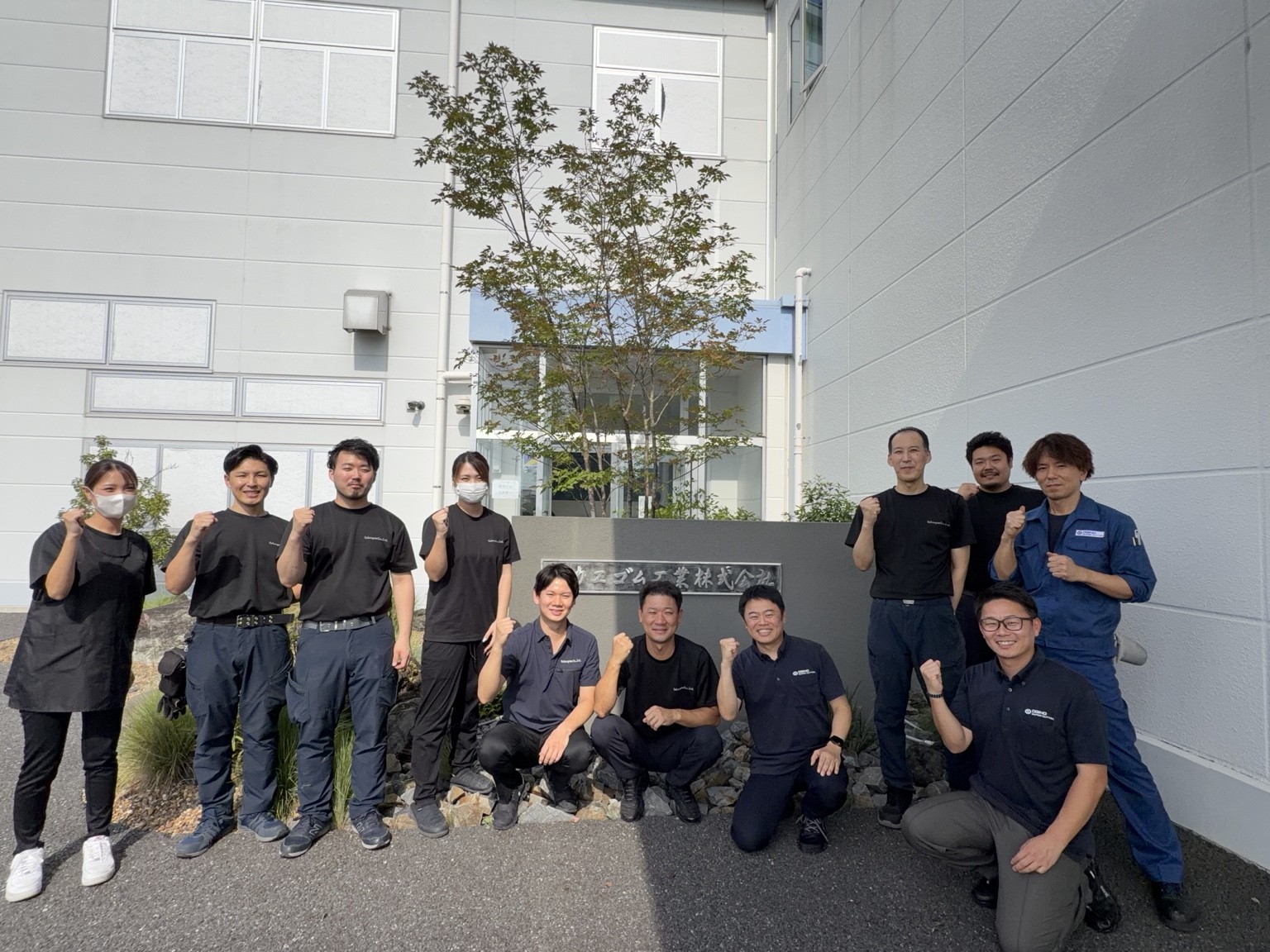 サカエゴム工業の社屋前に集まった同社の皆様と荻野精機製作所の訪問メンバー3名